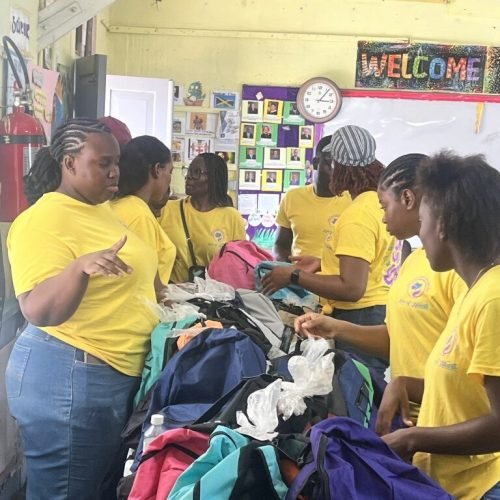 Volunteers and administrators organizing packages for the students at the back-to-school drive in Westmoreland Jamaica 2025