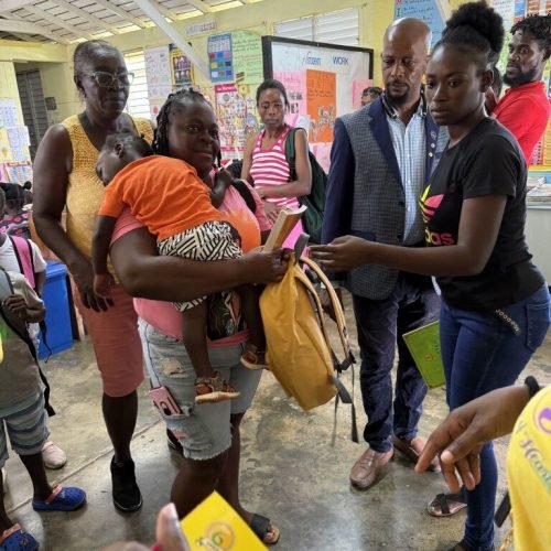 Happy Mom and student receiving their package from the Love of Hearts Foundation