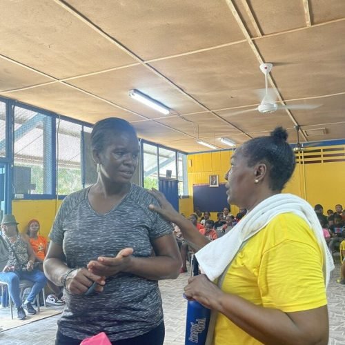 Love of Hearts Foundation member speaking with a parent at the Back-to-School Drive 2025
